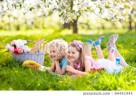 Family picnic in spring park. Kids eating outdoors Family picnic in spring park. Kids eating outdoors 94441445