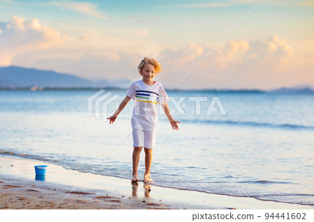 Kids play on tropical beach. Sand and water toy. 94441602