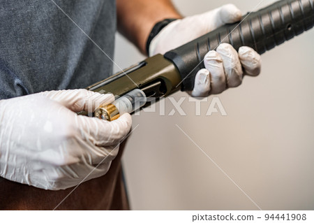 The gunsmith maintaining his rifle in a workshop The gunsmith maintaining his rifle in a workshop 94441908