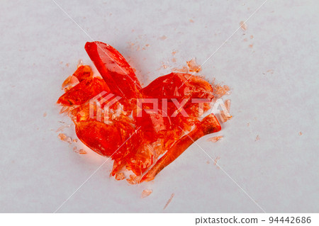 Close up broken heart lollipop on white surface. Broke up concept. Close up broken heart lollipop on white surface. Broke up concept. 94442686