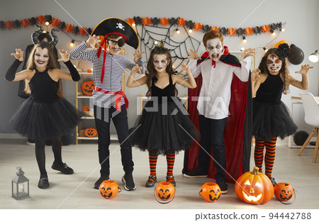 Group of happy children dressed up in spooky costumes having fun at Halloween party Group of happy children dressed up in spooky costumes having fun at Halloween party 94442788