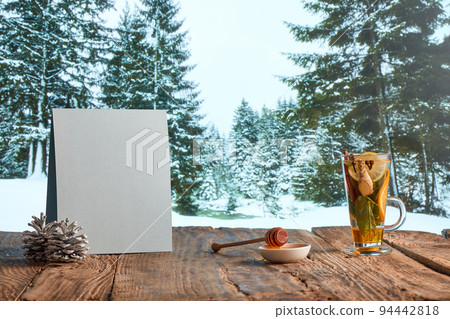 Homemade herbal or fruit tea. Glass pot, cup and sweets on wooden table over natural landscape background. Beauty, art, taste and traditions of countries 94442818