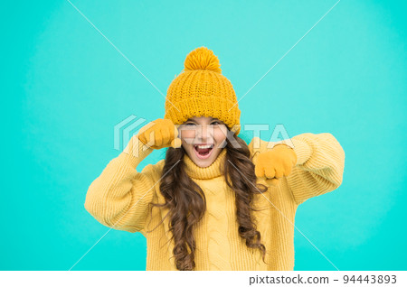 winter activity for kids. small girl playful mood turquoise background. little child ready to play. fashion and beauty. warm knitted clothes and accessory. feeling herself powerful and energetic 94443893