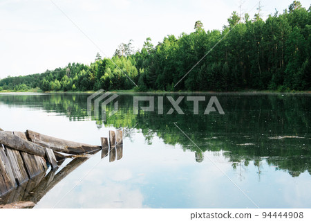 A beautiful landscape - flooding on the river bank and flooding of buildings on the bank. Natural disaster and destruction. A beautiful landscape - flooding on the river bank and flooding of buildings on the bank. Natural disaster and destruction. 94444908