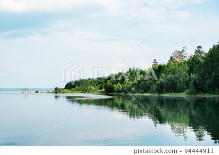 Beautiful landscape - spring flood on the river. The coast with the forest is flooded with water Beautiful landscape - spring flood on the river. The coast with the forest is flooded with water 94444911
