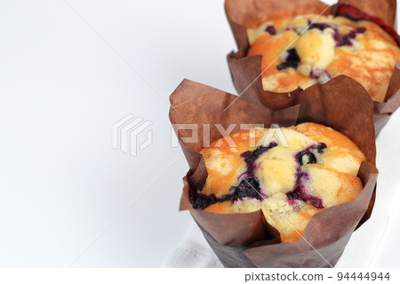 close up freshly baked blueberry muffins in paper cupcake holder on a white tissue paper close up freshly baked blueberry muffins in paper cupcake holder on a white tissue paper 94444944