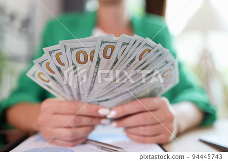 Business woman holding fan of dollars and financial income 94445743