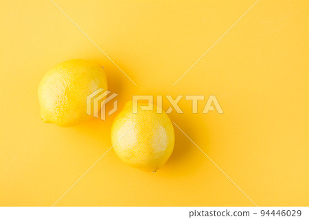 Two ripe whole lemons on a yellow background. Detox fruit diet, body detoxification. Top view Two ripe whole lemons on a yellow background. Detox fruit diet, body detoxification. Top view 94446029