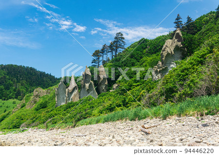 coastal landscape, beautiful lava rocks on the green coast of Kunashir island 94446220