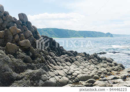 gray basalt rocks against a blurred coastal seascape gray basalt rocks against a blurred coastal seascape 94446223