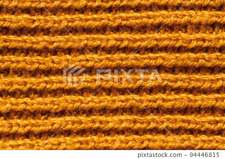 Background of yellow knitted woolen thread close-up 94446815