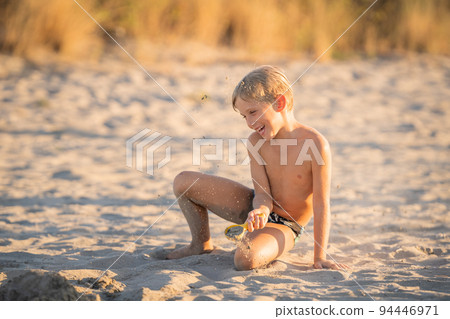 joyful kid having fun with sand on the beach joyful kid having fun with sand on the beach 94446971