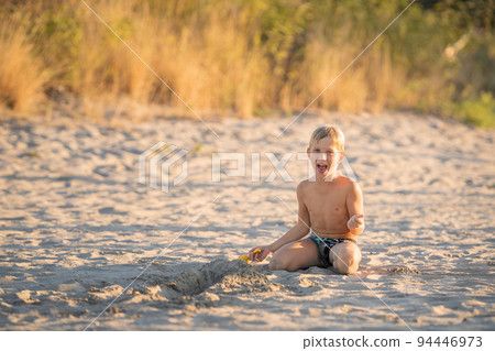Little boy laughing on the beach summer holidays 94446973