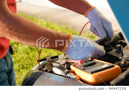 Replacing the battery before winter. Car maintenance before the cold season. Close up hand of Male mechanic changing car battery, engineer is replacing car battery Replacing the battery before winter. Car maintenance before the cold season. Close up hand of Male mechanic changing car battery, engineer is replacing car battery 94447239