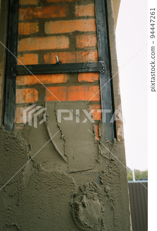 Construction concept. Cement plaster. The process of plastering a brick column. Construction concept. Cement plaster. The process of plastering a brick column. 94447261