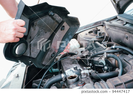 Car repair. Auto mechanic working on car engine in mechanics garage. Repair service. Close up of car mechanic repairer technician repairs auto engine 94447417
