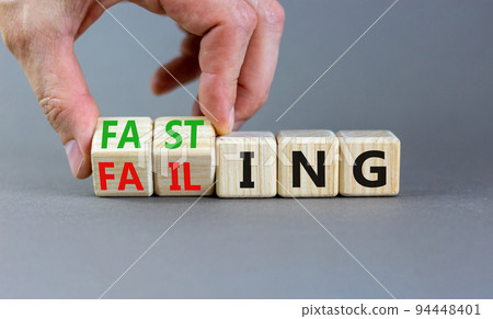 Fasting or failing symbol. Concept words Fasting or Failing on wooden cubes. Businessman hand. Beautiful grey table grey background. Business fasting or failing concept. Copy space. 94448401