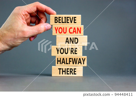 You can symbol. Concept words Believe you can and you are halfway there on wooden blocks on a beautiful grey table grey background. Businessman hand. Business motivational and you can concept. You can symbol. Concept words Believe you can and you are halfway there on wooden blocks on a beautiful grey table grey background. Businessman hand. Business motivational and you can concept. 94448411