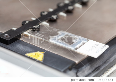 Slide during the process of preparation for karyotipe and fluorescence in situ hybridization - FISH in the laboratory. Drying of the glue applied to the cover glass. 94448723