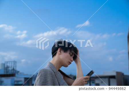 Portrait of a man using a smartphone on the rooftop 94449862