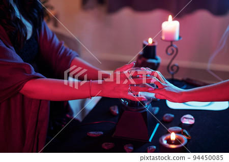 Hands of psychic and client putting hands of cystal ball to see future Hands of psychic and client putting hands of cystal ball to see future 94450085