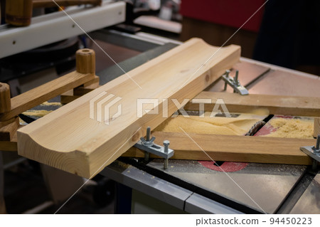 Carpenter workbench with industrial circular saw machine, wooden boards 94450223