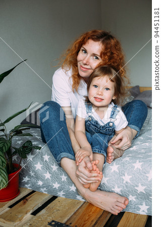 Young mother and child have fun and fool around at home on the bed 94451181