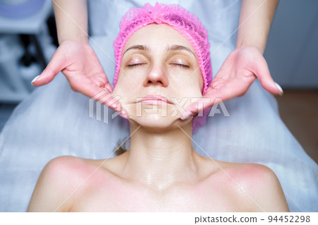 Attractive female at spa health club getting a facial massage. Beautician doing massage of face, neck and shoulders ofbeautiful young woman at luxury beauty salon 94452298