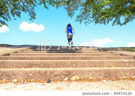 Woman in sportswear running up the stairs Woman in sportswear running up the stairs 94454226