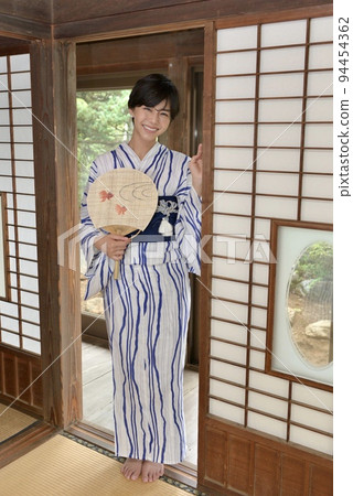一位穿著浴衣的年輕女子在一間舊私人住宅的日式房間裡擺姿勢 94454362
