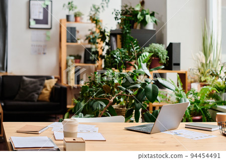Workplace of white collar worker in office decorated with green domestic plants Workplace of white collar worker in office decorated with green domestic plants 94454491