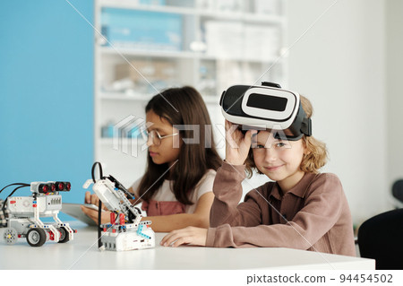 Happy youthful schoolchild taking off vr headset and looking at camera Happy youthful schoolchild taking off vr headset and looking at camera 94454502