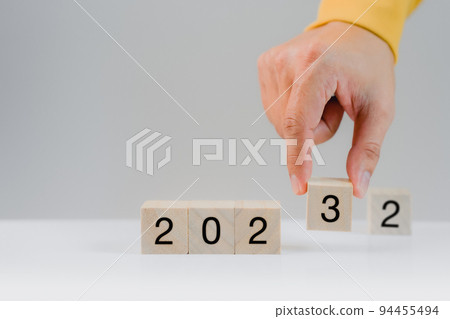 Hand holding a wooden cube with numbers 2023 on white background. Goal in the new year 2023. Business development strategy, advancement and goal concept Hand holding a wooden cube with numbers 2023 on white background. Goal in the new year 2023. Business development strategy, advancement and goal concept 94455494