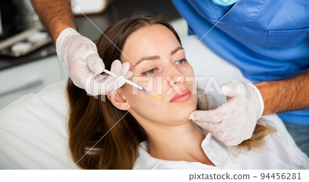 Female client during face mesotherapy in cosmetology clinic Female client during face mesotherapy in cosmetology clinic 94456281