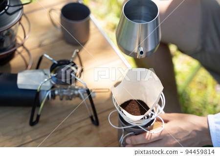 Hand dripping coffee outdoors Hand dripping coffee outdoors 94459814