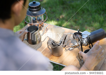 Hand dripping coffee outdoors Hand dripping coffee outdoors 94459881