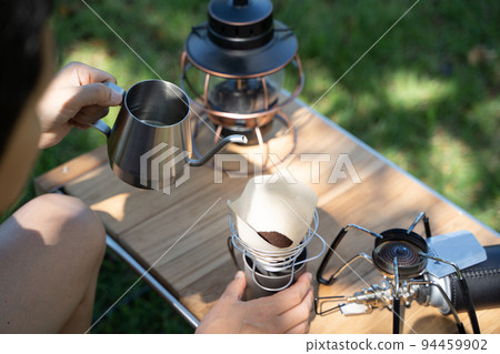 Hand dripping coffee outdoors Hand dripping coffee outdoors 94459902