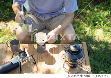 Hand dripping coffee outdoors Hand dripping coffee outdoors 94459947