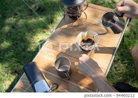 Hand dripping coffee outdoors 94460212