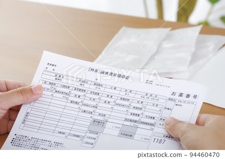 Woman looking at medical bill 94460470