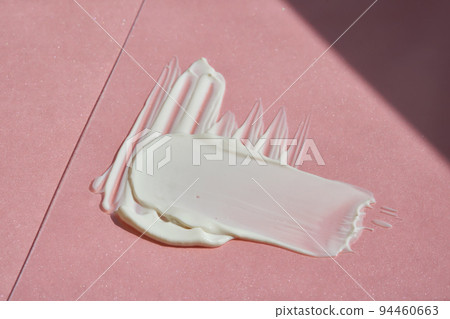White cosmetic cream on a pink background. 94460663
