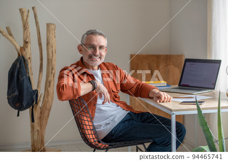 A bearded mature man sitting at the table in the office 94465741