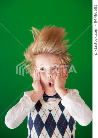 Surprised child against green chalkboard in class Surprised child against green chalkboard in class 94466683