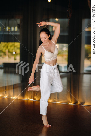 Portrait of a woman in white clothes dancing standing in the interior 94467886