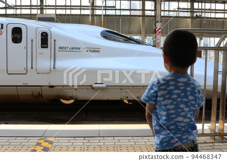 A child looking at the Kyushu Shinkansen at Shin-Osaka Station 94468347
