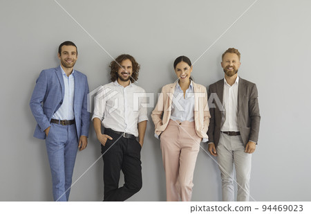 Team of happy confident business people in office wear standing in studio and smiling Team of happy confident business people in office wear standing in studio and smiling 94469023