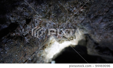 A drop of water hangs on the damp walls of cave A drop of water hangs on the damp walls of cave 94469096