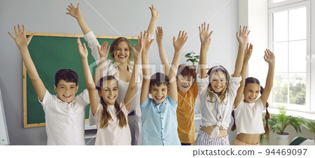 Funny group of elementary school classmates and their female teacher having fun in classroom. Funny group of elementary school classmates and their female teacher having fun in classroom. 94469097