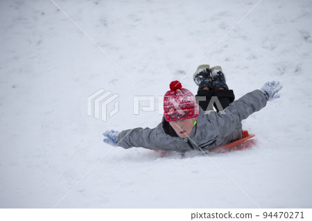 Child in winter. The boy is sledding. Child in winter. The boy is sledding. 94470271