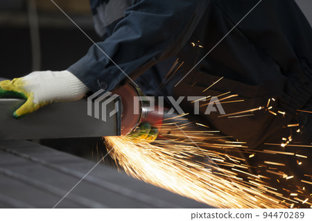 The welder cuts the pipe and fiery sparks fly.Worker cuts gas pipe with grinder, close up The welder cuts the pipe and fiery sparks fly.Worker cuts gas pipe with grinder, close up 94470289